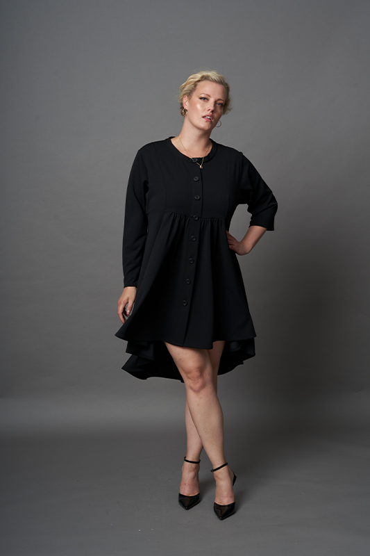 Made of scuba crepe, a black long sleeve hi-lo handkerchief dress with round neckline and relaxed silhouette from One Six styles.